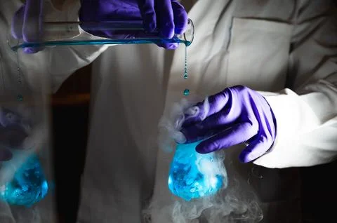Smoky experiments with blue colour solution.  Scientist working on chemical.. Stock Photos