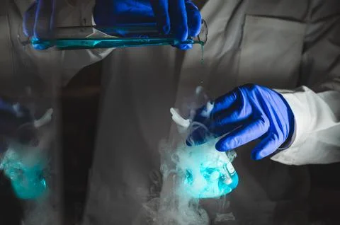Smoky experiments with blue colour solution.  Scientist working on chemical.. Stock Photos