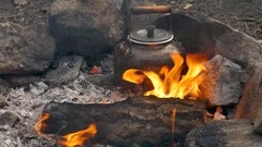 Camping kettle over burning campfire. Stock Photo