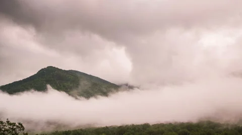 Smoky Mountain Surrounded by Clouds and Fog Time Lapse Stock Footage 42059276