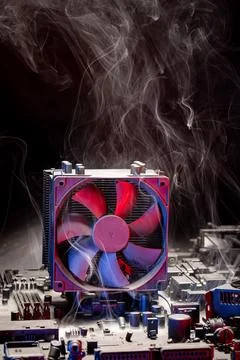 Smoky processor unit with heatsink during malfunction. Stock Photos