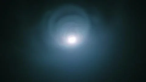 In a smoky space white rays with flares emerge from the center of frame and move Stock Footage 313163134