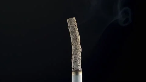 Smoldering cigarette on a black background. Close-up. 库存影片 140337516