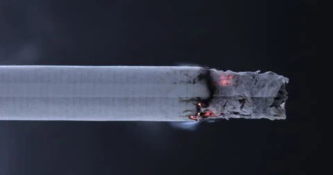 Smoldering cigarette on a black background. Stock Footage 129969200
