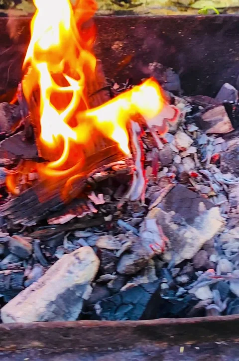 Smoldering coals and dancing flames in a cozy fire bowl in the backyard Stock Footage 319953098
