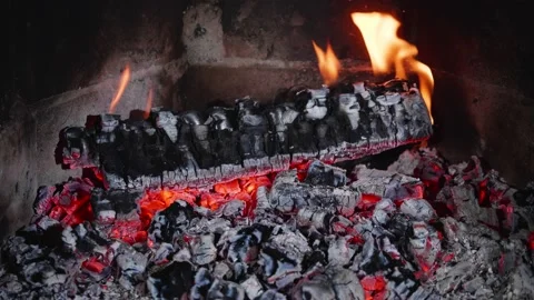 Smoldering heat and burning log in a fireplace Stock Footage 220904377
