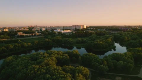 Smooth aerial flight over the evening city at sunset. A cityscape overview of Stock Footage 203727469