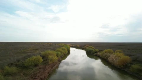 Smooth aerial flyover of winding river in Kazakh steppe 動画素材 334680707