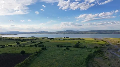 Smooth Aerial Pullback Over Lake and Green Farmland Video stock 345792902