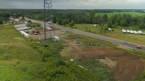 Smooth aerial pullback revealing rural road, and green fields in summer Video stock 314415172