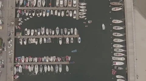 Smooth aerial RAW shot of motorboat in harbor, birds eye view Stock Footage