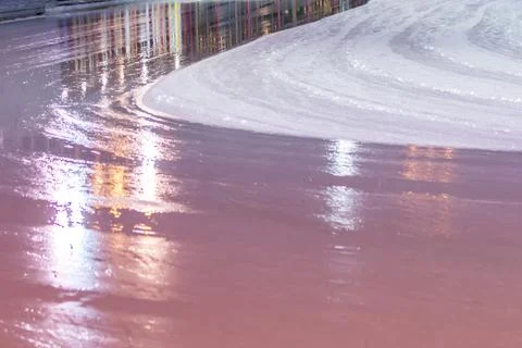 Smooth and shiny ice surface on the rink, reflecting colorful lights after Stock Photos
