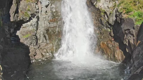 Smooth approach and ascent to the waterfall in the bowl between the rocks on a Stockbeeldmateriaal 264093042