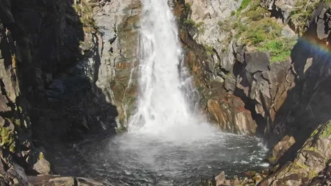 Smooth approach and ascent to the waterfall in the bowl between the rocks on a Stockbeeldmateriaal 264093094
