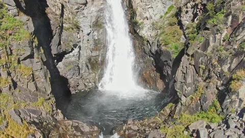 A smooth approach to the waterfall in the bowl between the rocks on a sunny day. Stock Footage 264092973