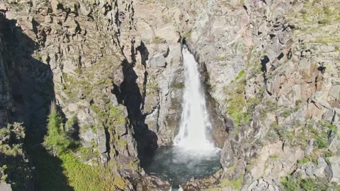 A smooth approach to the waterfall in the bowl between the rocks on a sunny day. Stock Footage 269302219