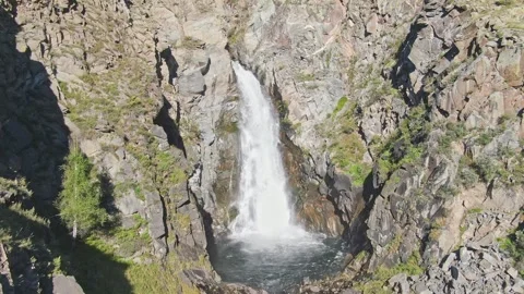 A smooth approach to the waterfall in the bowl between the rocks on a sunny day. Stock Footage 269303063