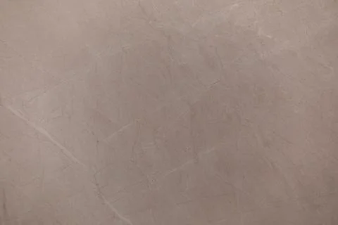 Smooth beige marble surface showcasing subtle veining patterns and natural Stock Photos