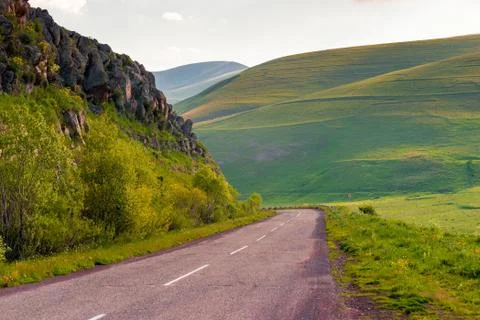 Smooth bends of mountain peaks, view of an empty highway in the mountains of  Stock Photos