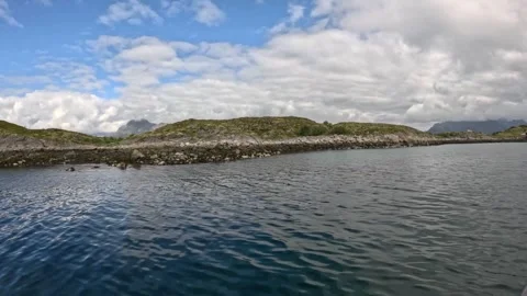 Smooth boat view passing green rocky islet in calm fjord water Lofoten Stock-Footage 344047466