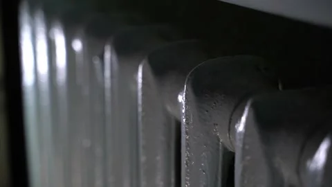 Smooth camera movement along an old cast-iron heating radiator, dark Stock Footage 236349866