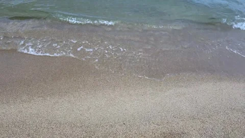 Smooth camera movement along sandy beach shoreline with crystal clear shallow Stock Footage 337104870