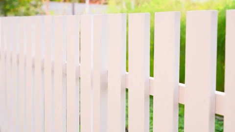 Smooth camera movement along a white wooden fence close-up on a blurred Stock Footage 231688691