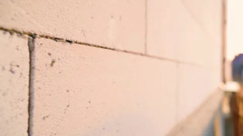 Smooth camera movement along a white aerated concrete wall at dawn Stock Footage 306587061