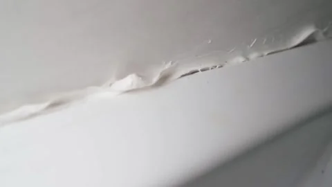 Smooth camera movement close-up of poor quality white sealant. Sealing joints Stock Footage 306269614
