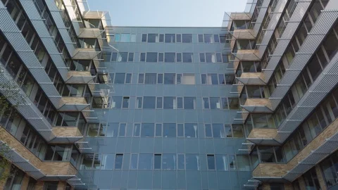 Smooth camera movement in front of office building windows reflecting sunny blue Stock Footage 122211896