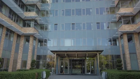 Smooth camera movement in front of office building windows reflecting sunny blue Stock Footage 122211968