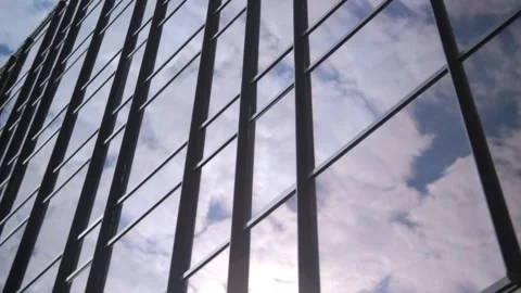 Smooth camera movement in front of the windows of an office building reflecting Видео 252203867