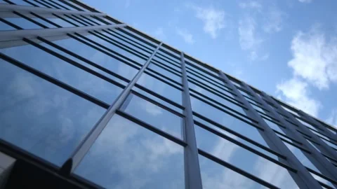 Smooth camera movement in front of the windows of an office building reflecting Stock Footage 252820613