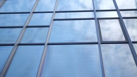 Smooth camera movement in front of the windows of an office building reflecting Stock Footage 252866026