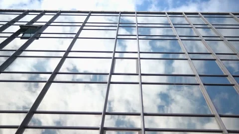Smooth camera movement in front of the windows of an office building reflecting Stock Footage 252874413