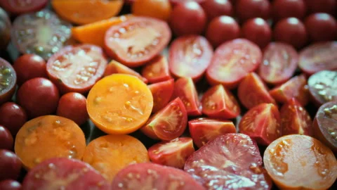 Smooth camera movement over sliced yellow and red tomatoes. Glistening juice Stock Footage 345528512