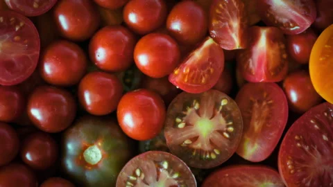 Smooth camera movement over sliced organic tomatoes in various yellow and re Stock Footage 346393388