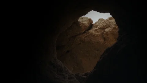 Smooth camera movement through a little cave hole in Portugal with brown rocks Stock Footage 94713002