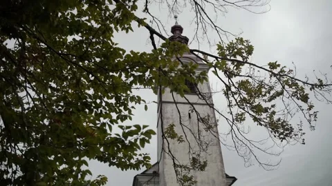 Smooth camera movement towards the old church through the branches Stock Footage 266597293