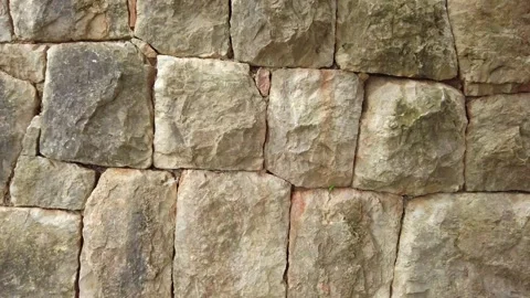Smooth camera pan revealing a perfectly formed medieval stone wall made of large Stock Footage 288594498