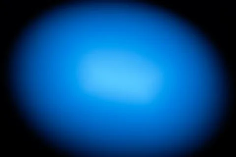 A smooth, circular gradient of blue light fades into a dark background Foto stock