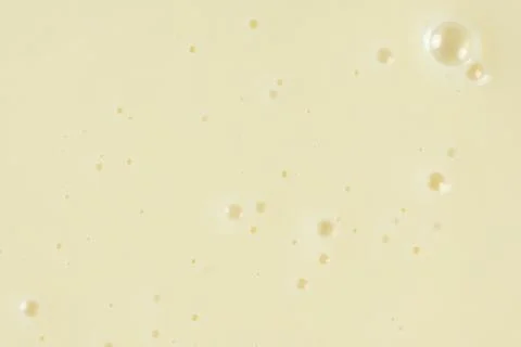 Smooth condensed milk texture with tiny bubbles macro. Stock Photos