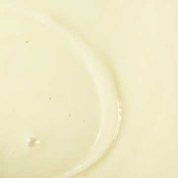 Smooth condensed milk texture with tiny bubbles macro. Stockfoto's