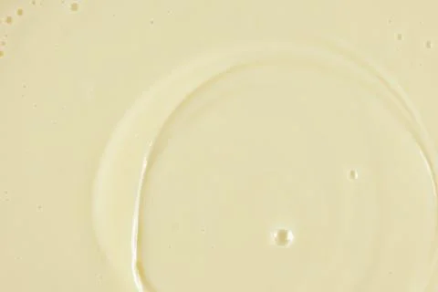 Smooth condensed milk texture with tiny bubbles macro. Stock Photos