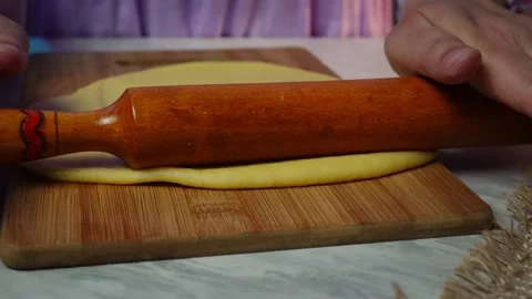 Smooth dough rolling action with wooden rolling pin on wooden board Stock Footage 318182256