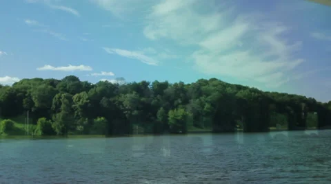 Smooth driving past the bank of the river with trees and bushes Stockbeeldmateriaal 35673108