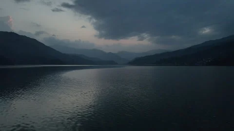 Smooth drone flight across Phewa Lake with a moving tourist paddle boat. Stock Footage 244729395