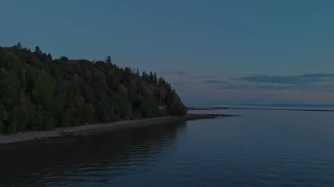 Smooth drone flight glides over calm sea surface tracking around shoreline Stock Footage 333923072