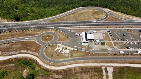 Smooth drone flight over gas station and road junction in green valley Stock Footage 323504124