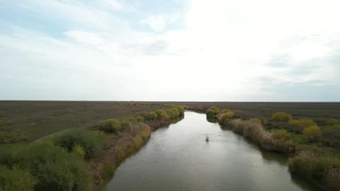 Smooth drone flyover above winding river in Kazakh steppe 動画素材 334325732